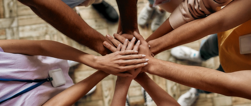 Hands gathered in middle forming a circle