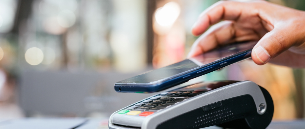 person paying with phone via contactless payment