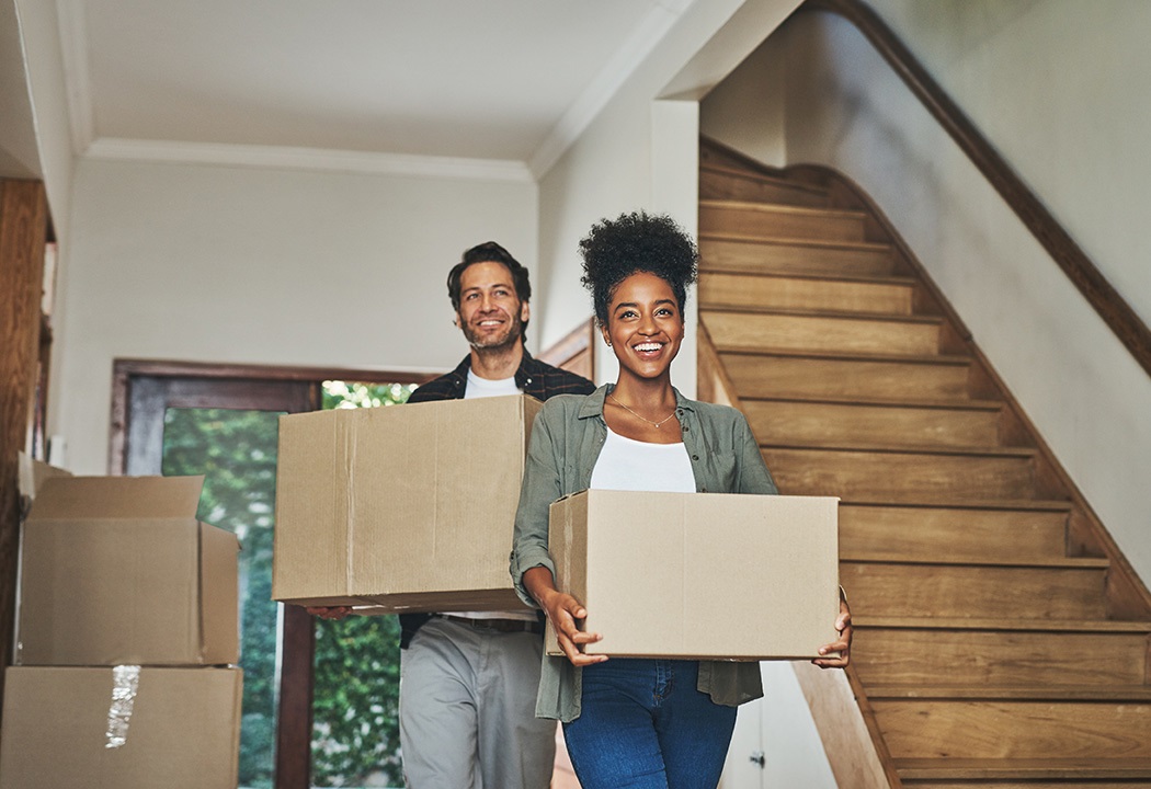  Young couple moving boxes into new home